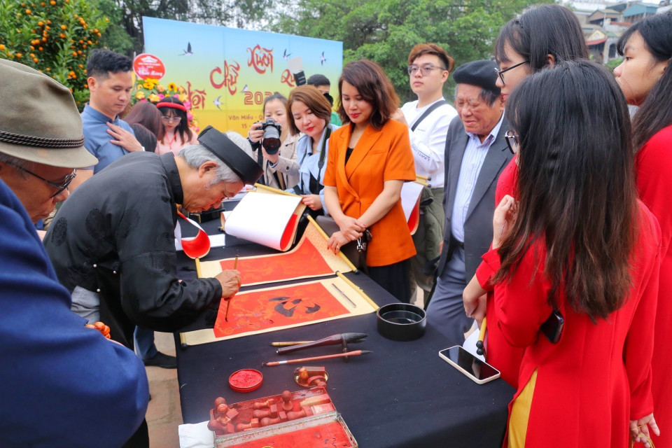 Các nghệ nhân viết thư pháp tại Hội chữ Xuân. (Ảnh: Tuấn Đức/TTXVN)