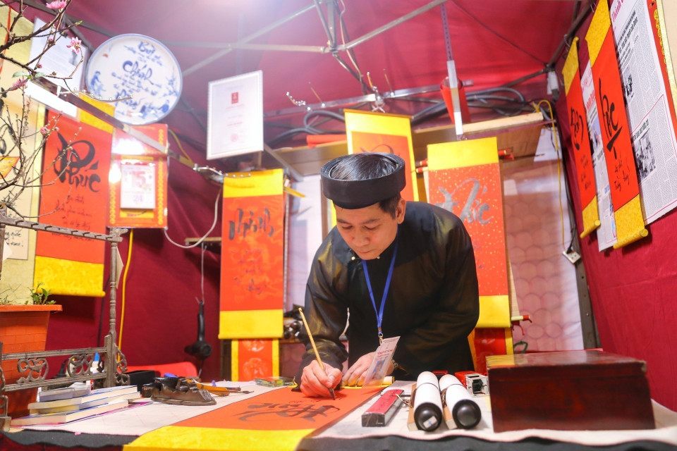 Các nghệ nhân viết thư pháp tại Hội chữ Xuân. (Ảnh: Tuấn Đức/TTXVN)