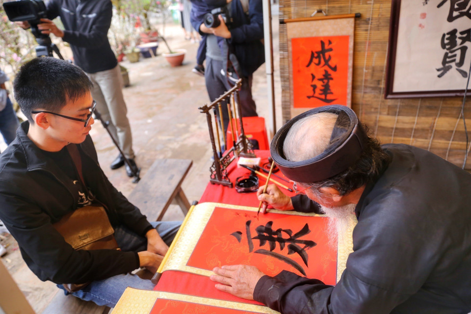 Các nghệ nhân viết thư pháp tại Hội chữ Xuân. (Ảnh: Tuấn Đức/TTXVN)