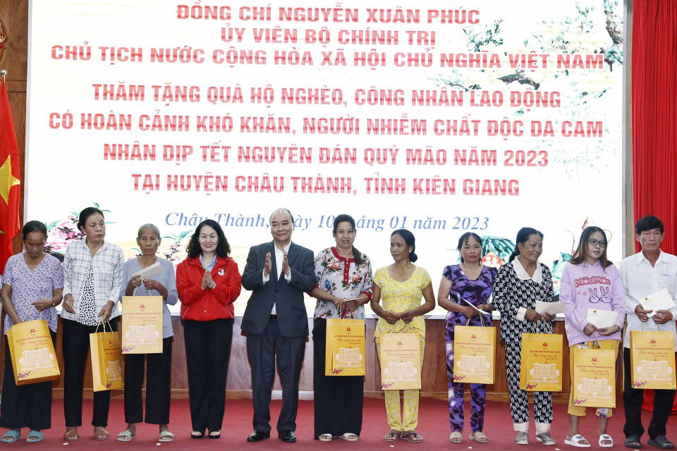 Chủ tịch nước Nguyễn Xuân Phúc tặng quà cho hộ nghèo, công nhân lao động có hoàn cảnh khó khăn, người nhiễm chất độc da cam trên địa bàn. (Ảnh: Thống Nhất/TTXVN)