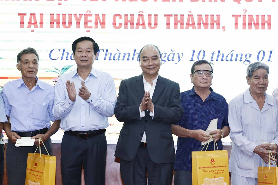 Chủ tịch nước Nguyễn Xuân Phúc tặng quà cho hộ nghèo, công nhân lao động có hoàn cảnh khó khăn, người nhiễm chất độc da cam trên địa bàn. (Ảnh: Thống Nhất/TTXVN)