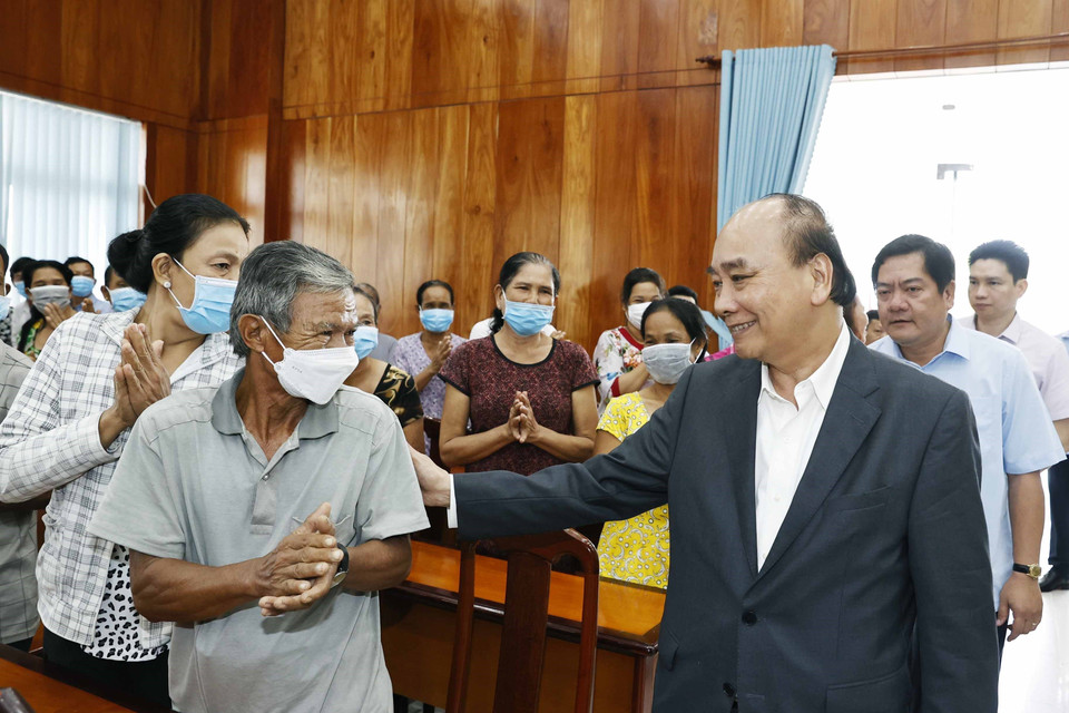 Chủ tịch nước Nguyễn Xuân Phúc hỏi thăm hộ nghèo, công nhân lao động có hoàn cảnh khó khăn, người nhiễm chất độc da cam tại huyện Châu Thành. (Ảnh: Thống Nhất/TTXVN)