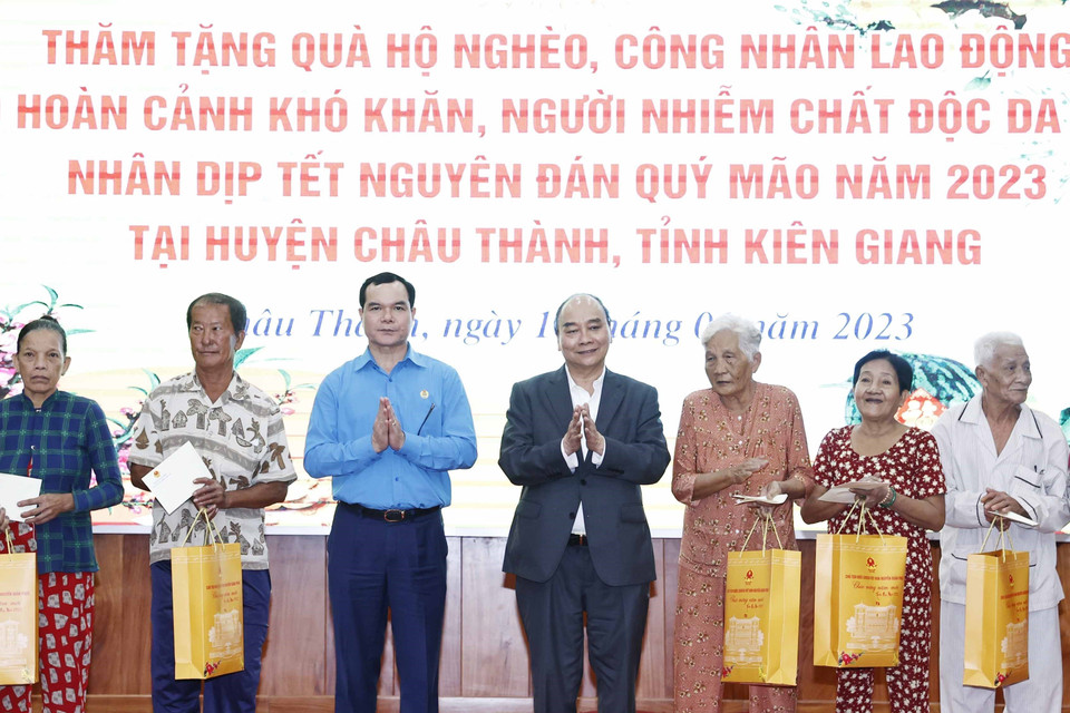 Chủ tịch nước Nguyễn Xuân Phúc tặng quà cho hộ nghèo, công nhân lao động có hoàn cảnh khó khăn, người nhiễm chất độc da cam trên địa bàn. (Ảnh: Thống Nhất/TTXVN)