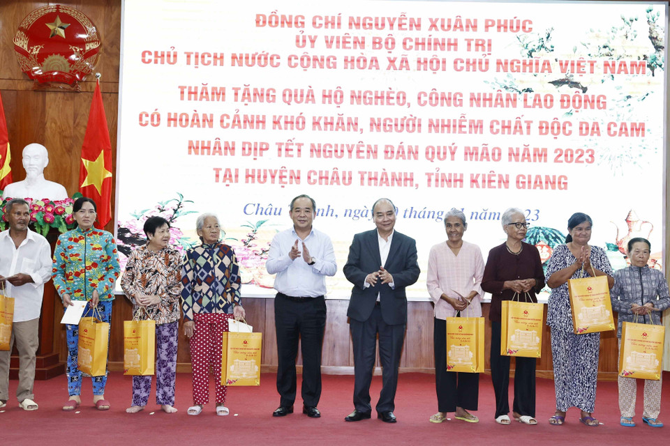 Chủ tịch nước Nguyễn Xuân Phúc tặng quà cho hộ nghèo, công nhân lao động có hoàn cảnh khó khăn, người nhiễm chất độc da cam trên địa bàn. (Ảnh: Thống Nhất/TTXVN)