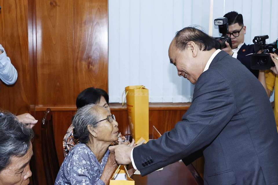 Chủ tịch nước Nguyễn Xuân Phúc tặng quà cho hộ nghèo, công nhân lao động có hoàn cảnh khó khăn, người nhiễm chất độc da cam trên địa bàn. (Ảnh: Thống Nhất/TTXVN)