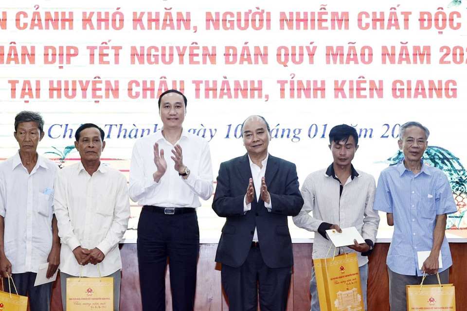 Chủ tịch nước Nguyễn Xuân Phúc tặng quà cho hộ nghèo, công nhân lao động có hoàn cảnh khó khăn, người nhiễm chất độc da cam trên địa bàn. (Ảnh: Thống Nhất/TTXVN)