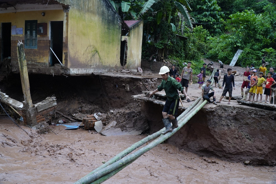 Việc đi lại của người dân sau lũ rất khó khăn. (Ảnh: Xuân Tư/TTXVN)