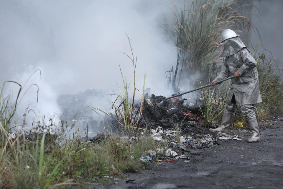 Các chiến sỹ phòng cháy chữa cháy tích cực khống chế ngọn lửa lây lan sang khu vực lân cận. (Ảnh: Thành Đạt/TTXVN)