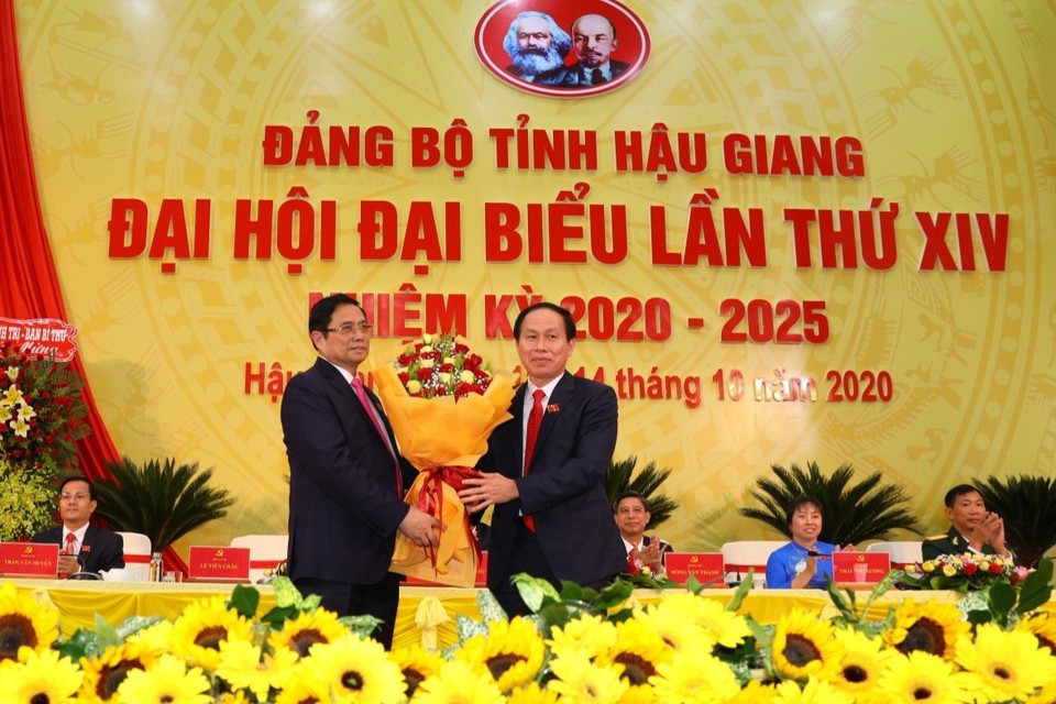 Ông Phạm Minh Chính, Ủy viên Bộ Chính trị, Bí thư Trung ương Đảng, Trưởng Ban Tổ chức Trung ương tặng hoa chúc mừng tại Đại hội Đảng bộ tỉnh Hậu Giang lần thứ XIV, nhiệm kỳ 2020-2025. (Ảnh: Duy Khương/TTXVN)