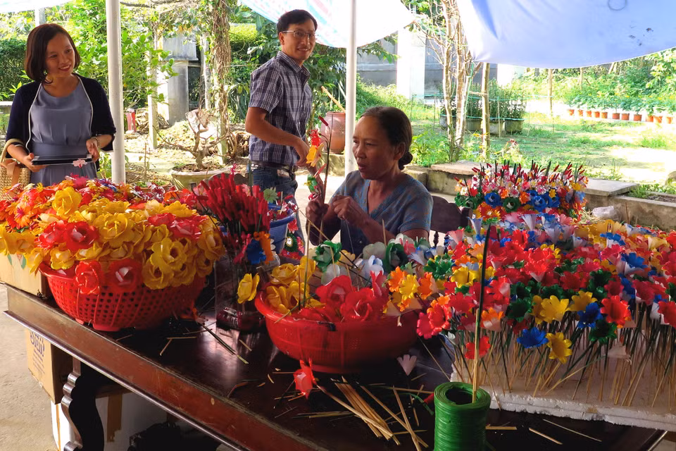 Nhiều du khách đến với làng nghề để tìm hiểu và trải nghiệm các công đoạn làm hoa. (Ảnh: Tường Vi/TTXVN)