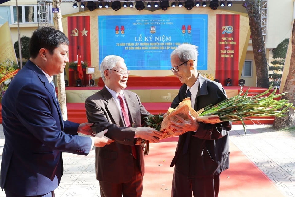Giáo sư, Tiến sỹ Nguyễn Phú Trọng, Tổng Bí thư, Chủ tịch nước, cựu học sinh nhà trường tặng hoa chúc mừng nhà giáo Lê Đức Giảng, nguyên Bí thư Chi bộ, Giáo viên chủ nhiệm lớp 10B - Trường Nguyễn Gia Thiều gần 60 năm về trước Thiều tại Lễ kỷ niệm 70 năm thành lập Trường Trung học phổ thông Nguyễn Gia Thiều (1950-2020). (Ảnh: Trí Dũng/TTXVN)