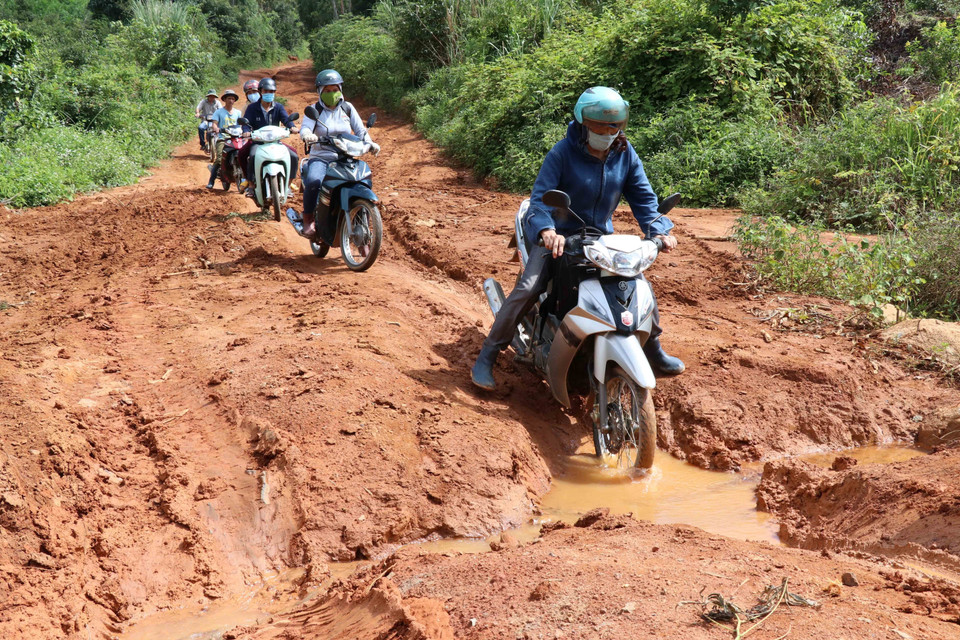 Cô Hà Thị Linh (đi đầu) giáo viên trường Tiểu học Hra số 2 (Gia Lai) trên đường lên điểm trường Đê Kôn trước năm học mới. Dù bị ngăn cách bởi con đường đèo nguy hiểm, trơn trợt mùa tựu trường nhưng những giáo viên nơi đây vì niềm yêu nghề, mến trẻ vẫn ngày ngày vượt hiểm nguy mang con chữ đến với học sinh nghèo vùng cao. (Ảnh: Hồng Điệp/TTXVN)