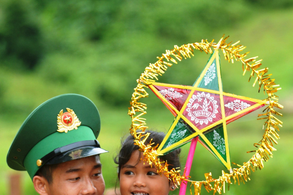 Các em nhỏ được tặng quà và đèn ông sao. (Ảnh: Võ Dung/TTXVN)