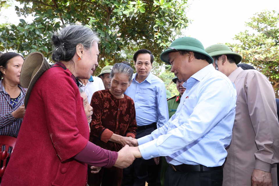 Thủ tướng Nguyễn Xuân Phúc thăm hỏi, chia sẻ khó khăn, mất mát với nhân dân thôn Đồng Tư, xã Hiền Ninh, huyện Quảng Ninh, tỉnh Quảng Bình. (Ảnh: Thống Nhất/TTXVN)