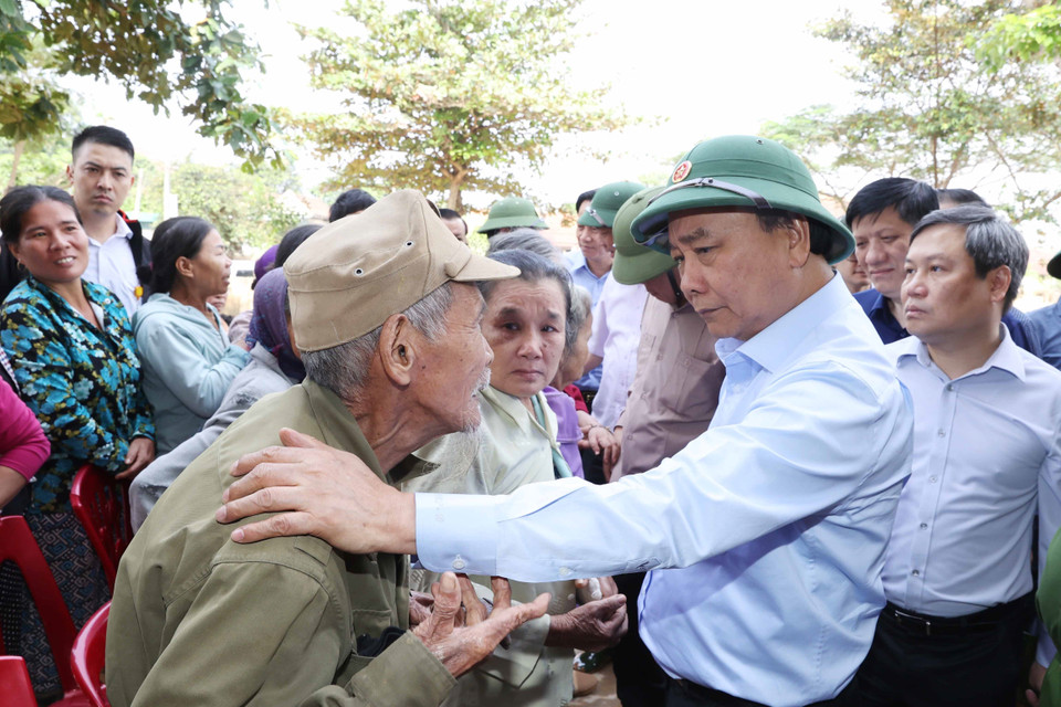 Thủ tướng Nguyễn Xuân Phúc thăm hỏi, chia sẻ khó khăn, mất mát với nhân dân thôn Đồng Tư, xã Hiền Ninh, huyện Quảng Ninh, tỉnh Quảng Bình. (Ảnh: Thống Nhất/TTXVN)