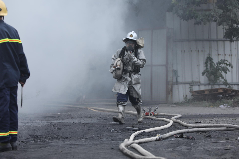 Các chiến sỹ phòng cháy chữa cháy tích cực khống chế ngọn lửa lây lan sang khu vực lân cận. (Ảnh: Thành Đạt/TTXVN)