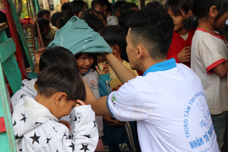  Các em học sinh nhóm thiện nguyện Fly to Sky mang áo ấm đến cho trẻ em làng Đê Kôn. (Ảnh: Hồng Điệp/TTXVN)