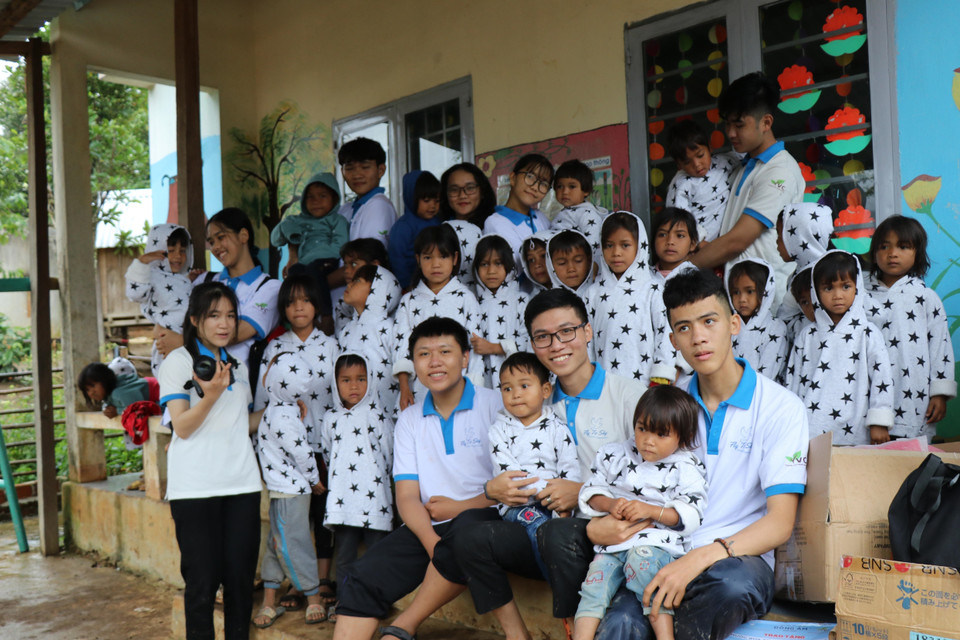 Các em học sinh nhóm thiện nguyện Fly to Sky mang áo ấm đến cho trẻ em làng Đê Kôn. (Ảnh: Hồng Điệp/TTXVN)