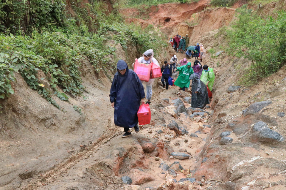Nhóm từ thiện Fly to Sky vượt đèo cõng từng thùng áo ấm đến cho trẻ em làng Đê Kôn. (Ảnh: Hồng Điệp/TTXVN)