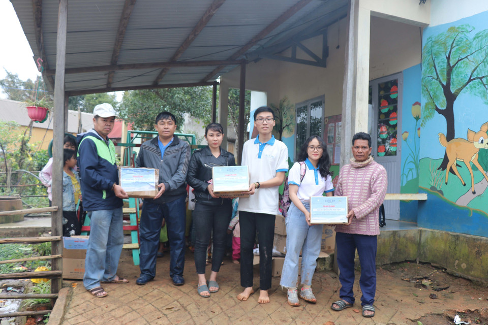 Các em học sinh nhóm thiện nguyện Fly to Sky mang áo ấm, sách truyện và bình lọc nước đến cho trẻ em làng Đê Kôn. (Ảnh: Hồng Điệp/TTXVN)