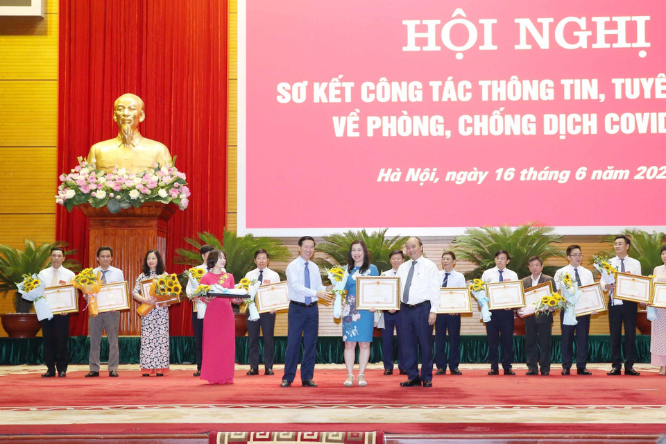 Thủ tướng Nguyễn Xuân Phúc và Trưởng Ban Tuyên giáo Trung ương Võ Văn Thưởng tặng Bằng khen của Thủ tướng cho các tập thể, cá nhân về thành tích trong thông tin, tuyên truyền phòng, chống COVID-19, ngày 16/6/2020. (Ảnh: Thống Nhất/TTXVN)