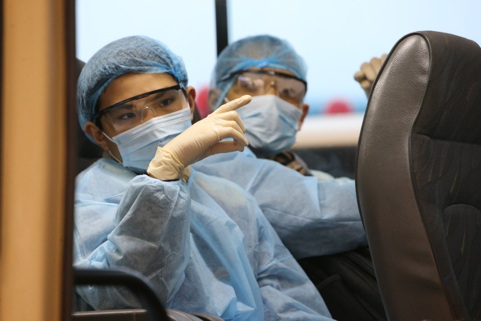 Công dân Việt Nam rời sân bay Vân Đồn đến khu vực cách ly để theo dõi và điều trị. (Ảnh: Dương Giang/TTXVN)