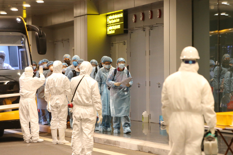 Các công dân Việt Nam được hướng dẫn khử trùng và làm thủ tục dưới sự giám sát của các nhân viên y tế. (Ảnh: Dương Giang/TTXVN)