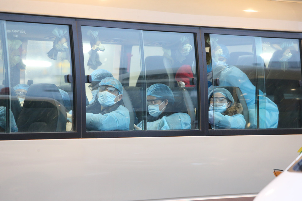 Xe đưa các công dân Việt Nam rời sân bay Vân Đồn đến khu vực cách ly để theo dõi và điều trị. (Ảnh: Dương Giang/TTXVN)