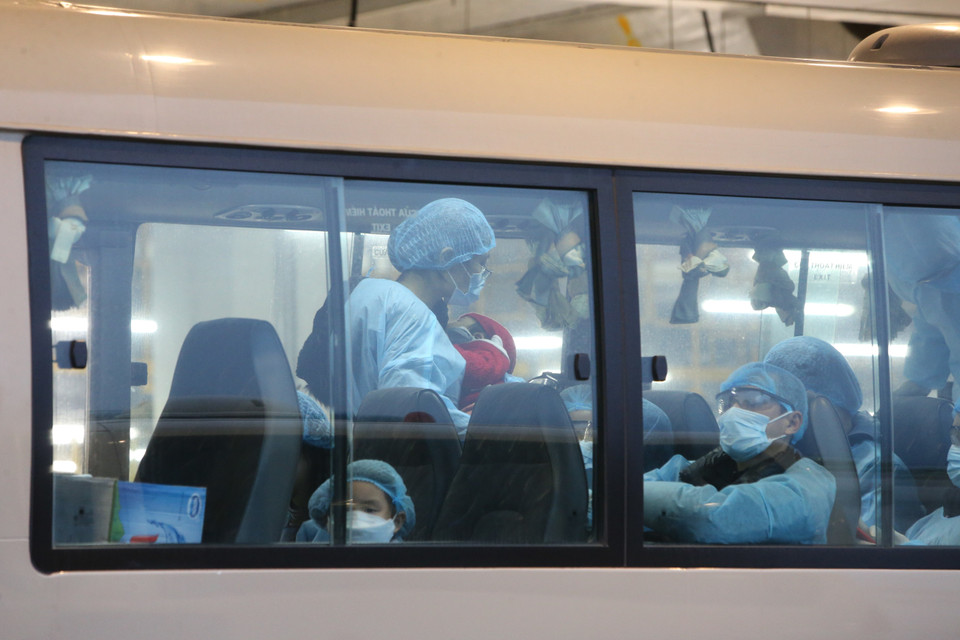 Xe đưa các công dân Việt Nam rời sân bay Vân Đồn đến khu vực cách ly để theo dõi và điều trị. (Ảnh: Dương Giang/TTXVN)