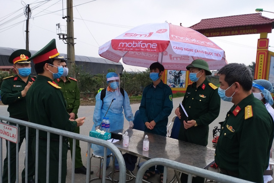 Các lực lượng triển khai nhiệm vụ cách ly y tế tại thôn Hạ Lôi. (Ảnh: Nguyễn Cúc/TTXVN)