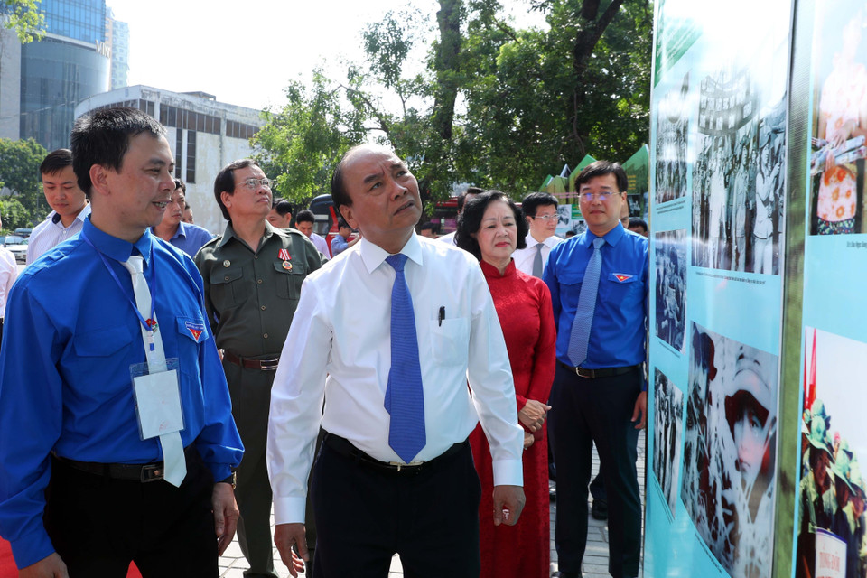 Thủ tướng Nguyễn Xuân Phúc thăm không gian trưng bày hình ảnh về lực thượng thanh niên xung phong. (Ảnh: Thống Nhất/TTXVN)
