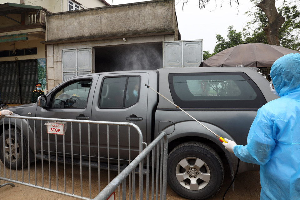 Phun khử khuẩn xe ra vào khu vực xã Dũng Tiến. (Ảnh: Minh Quyết/TTXVN)