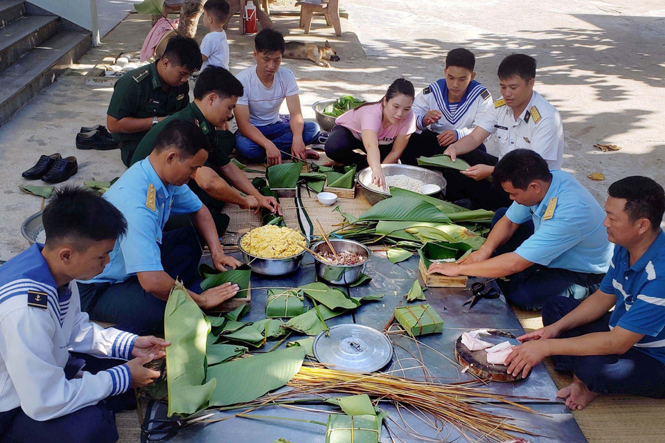  Người dân và cán bộ, chiến sỹ thị trấn Trường Sa quây quần gói bánh chưng, chuẩn bị đón Tết Nguyên đán. (Ảnh: Hoàng Hùng/TTXVN)
