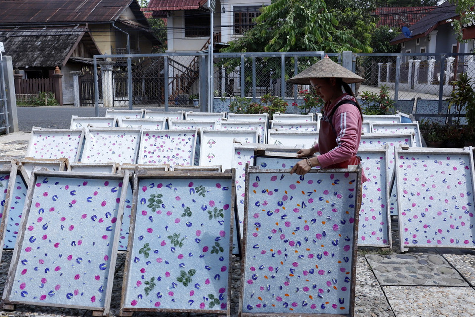 Giấy Saa sau khi được lên khung, trang trí được mang đi phơi nắng. (Ảnh: Phạm Kiên/TTXVN)