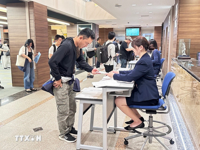 Thí sinh nhận thẻ vào phòng dự thi. (Ảnh: Nguyễn Tuyến/TTXVN) ttxvn-tieng-viet-tai-nhat-ban-2.jpg