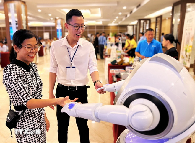 Các đại biểu tương tác với robot bên lề Hội thảo “Phát triển nguồn nhân lực khoa học công nghệ và đổi mới sáng tạo trình độ quốc tế" tại Cần Thơ, hồi tháng Bảy năm ngoái. (Ảnh: Ánh Tuyết/TTXVN) ttxvn-uom-mam-hoa-hoc-cong-nghe-3.jpg