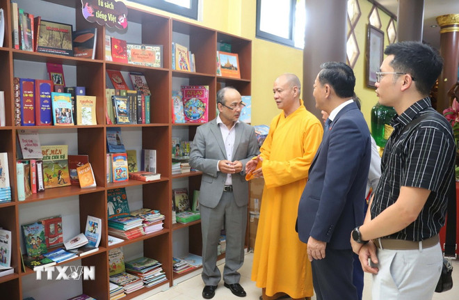 ព្រះចៅអធិការវត្ត Phat Tich នៅទីក្រុងវៀងចន្ទន៍ ណែនាំទូដាក់សៀវភៅ។ (រូបថត៖ Xuan Tu/VNA) ttxvn-tu-sach-tieng-viet-vientiane-1.jpg