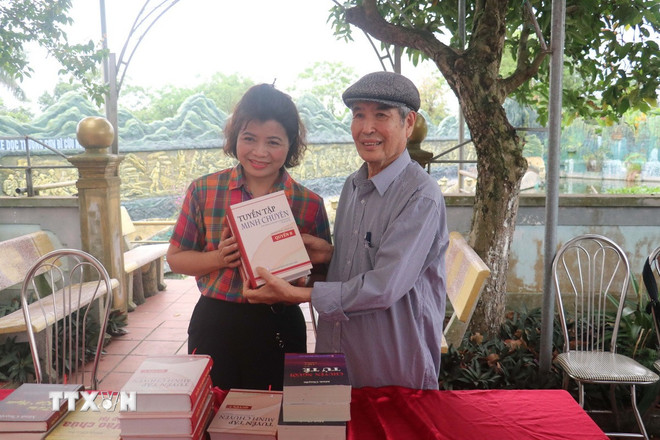 Nhà văn Minh Chuyên tặng sách cho đoàn cán bộ và sinh viên Trường Đại học Kinh doanh và Công nghệ Hà Nội. (Ảnh: Vũ Quang/TTXVN) ttxvn-nha-van-minh-chuyen-2.jpg