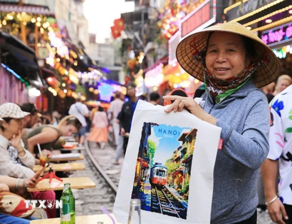 Một người hàng rong bán tranh in "phố càphê đường tàu." (Ảnh: Thành Phương/TTXVN)