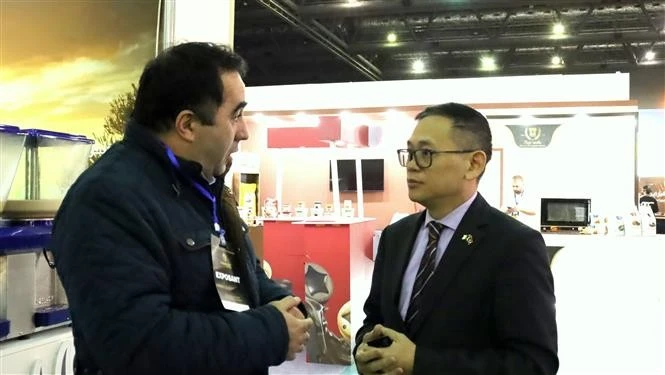 Đại sứ Việt Nam tại Algeria Trần Quốc Khánh trao đổi danh thiếp với doanh nghiệp Algeria. (Ảnh: Mạnh Hùng/TTXVN)