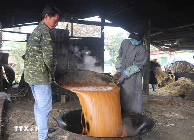 당밀이 걸쭉해지고 황금빛 노란색이 되면 불에서 내려 저어주어 재빨리 식힙니다. (사진: 추히우/VNA) ttxvn-duong-phen-bo-to-5.jpg