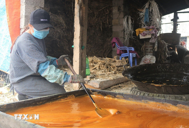 당밀은 틀에 응축되어 표면에 고르게 펴집니다. 식으면 커다란 설탕 덩어리가 형성됩니다. (사진: 추히우/VNA) ttxvn-duong-phen-bo-to-1.jpg