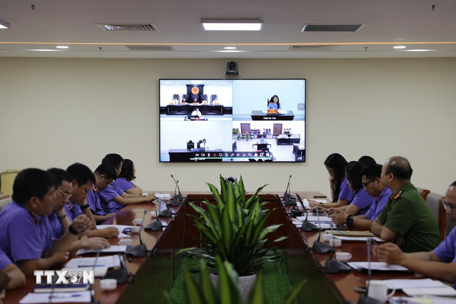 Các kiểm sát viên Viện Kiểm sát Nhân dân thành phố Hà Nội theo dõi phiên tòa rút kinh nghiệm trực tuyến qua hệ thống màn hình. (Ảnh: Quốc Lũy/TTXVN) ttxvn-xet-xu-hinh-su-truc-tuyen-2.jpg