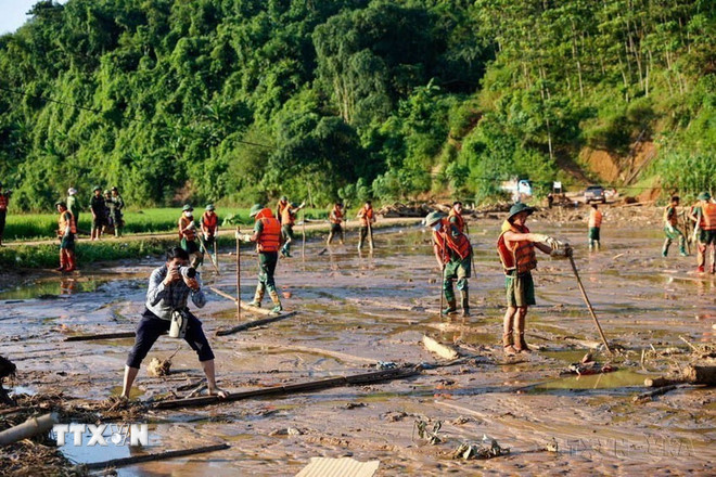 Phóng viên Dương Giang (Ban Biên tập ảnh) tác nghiệp tại khu vực sạt lở đất thuộc làng Nủ, xã Phúc Khánh, huyện Bảo Yên, tỉnh Lào Cai (2024). (Ảnh: TTXVN) ttxvn-phong-vien-2.jpg