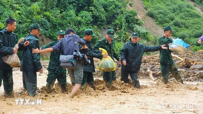 Phóng viên Cơ quan thường trú TTXVN tại Điện Biên Trịnh Xuân Tư băng qua suối nước chảy siết với sự giúp đỡ của các chiến sỹ Biên phòng để kịp thời thông tin về tình hình mưa lũ tại địa bàn, tháng 7/2024. (Ảnh: TTXVN) ttxvn-phong-vien-5.jpg
