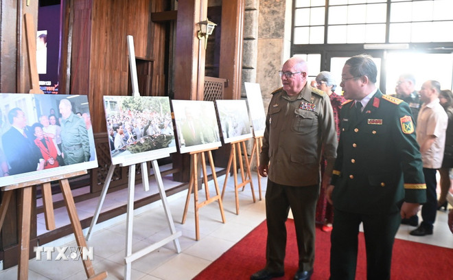 Senior Lieutenant General Álvaro Lópz Miera, Politburo member and Minister of the Cuban Revolutionary Armed Forces, looks at photos of the historic Vietnam-Cuba relationship. (Photo: Viet Hung/VNA) ttxvn-viet-nam-cuba-1.jpg