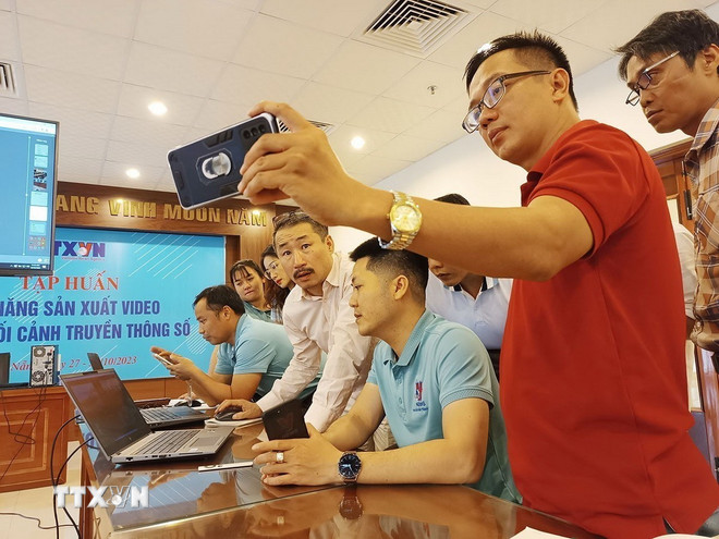 VNA reporters discuss how to make videos using mobile phones at the class “Video production skills in the context of digital media” held in Da Nang. (Photo: VNA) ttxvn-bao-chi-da-nen-tang-3.jpg