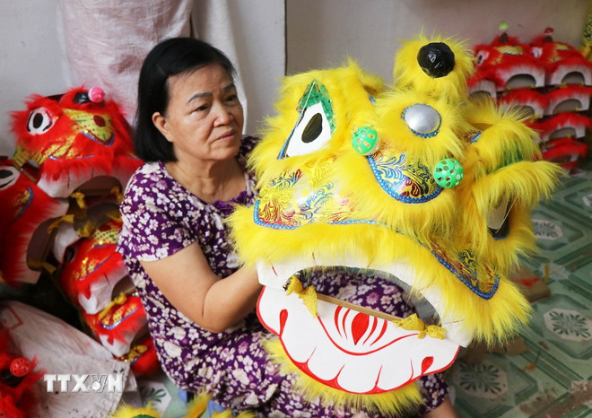Fru Truong Thi Kim Chis hushåll i Phu Xuan-distriktet i Hue stad tillverkar små lejonhuvuden för att sälja med anledning av midhöstfestivalen 2025. (Foto: Nguyen Ly/VNA) ttxvn-dau-lan-trung-thu-8.jpg