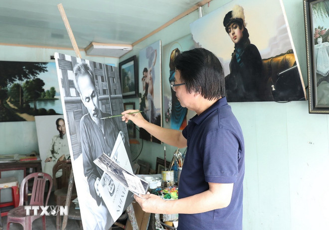 Artist Tran Hoa Binh paints a portrait of Uncle Ho. (Photo: Duc Phuong/VNA) ttxvn-hoa-sy-tran-hoa-binh-1.jpg