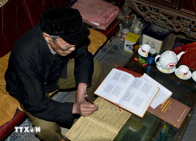 O Sr. Tan Kim Phu, detentor do patrimônio cultural imaterial do grupo étnico Dao em Sin Ho, é o último artesão excepcional que ainda consegue ler e compreender os livros antigos do povo Dao no planalto de Sin Ho. (Foto: VNA) ttxvn-tieng-dan-toc.jpg